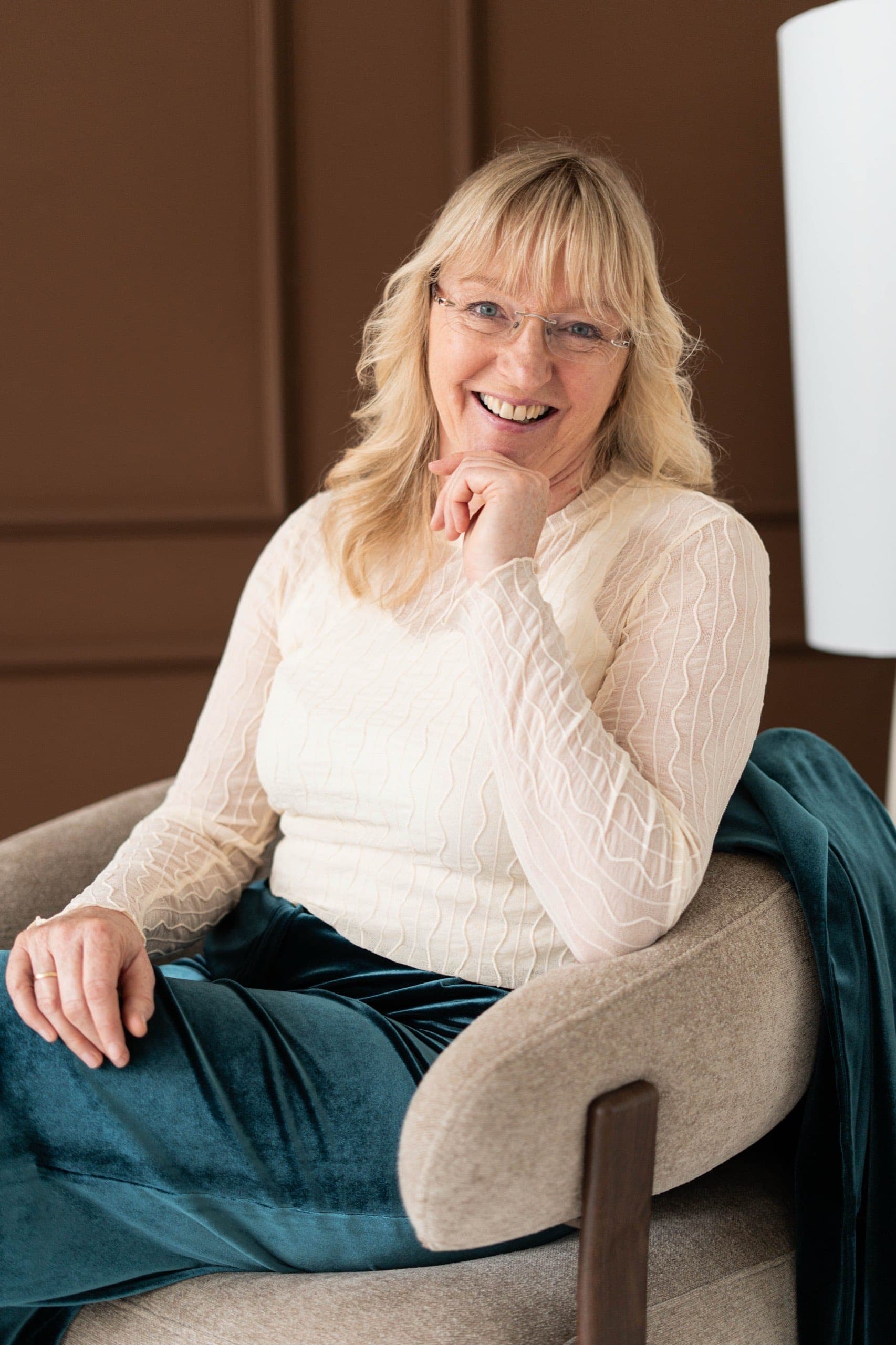 Personal branding portret van een lachende onderneemster in een fauteuil