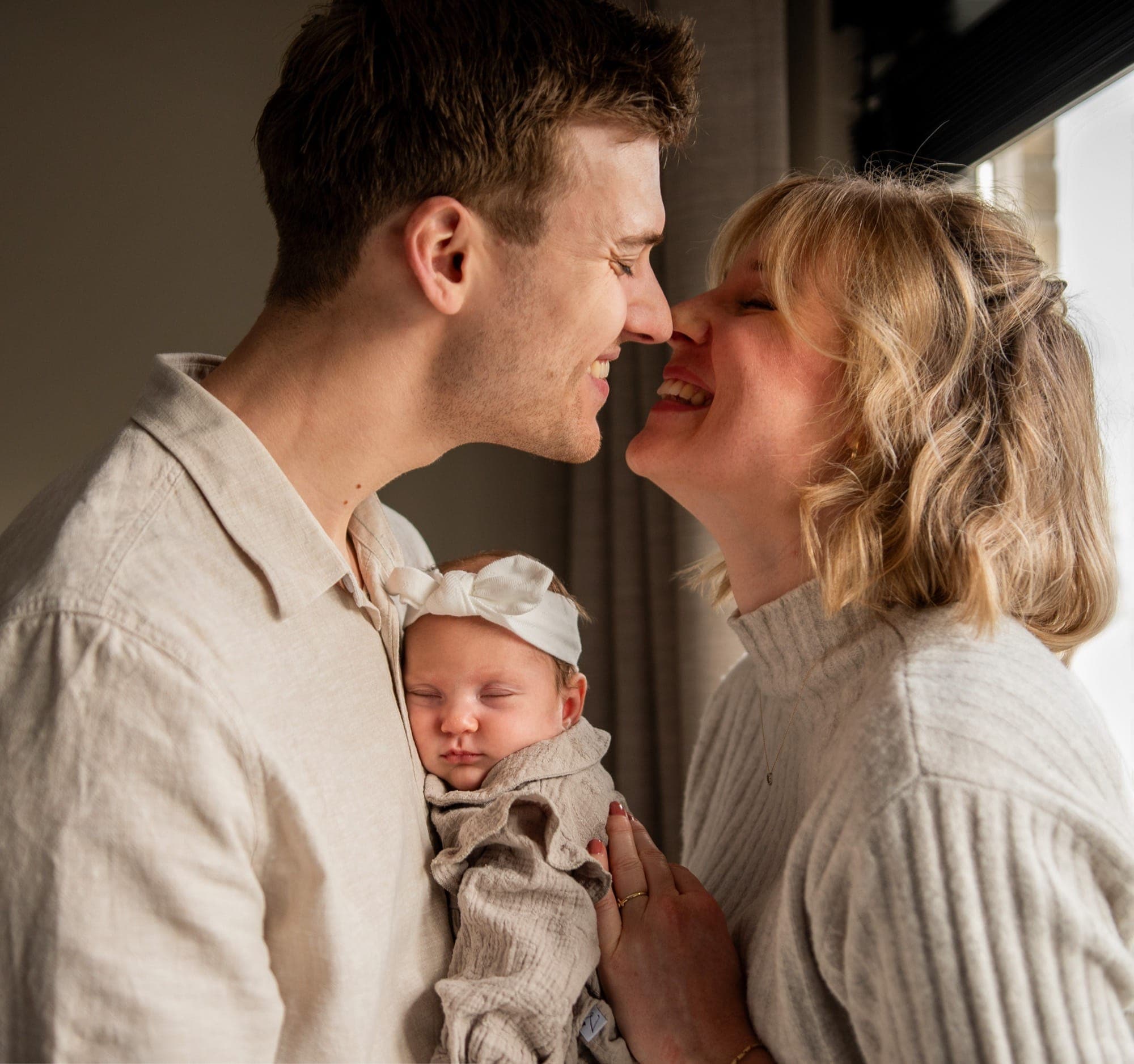 Ouders neus aan neus met hun pasgeboren baby in de armen
