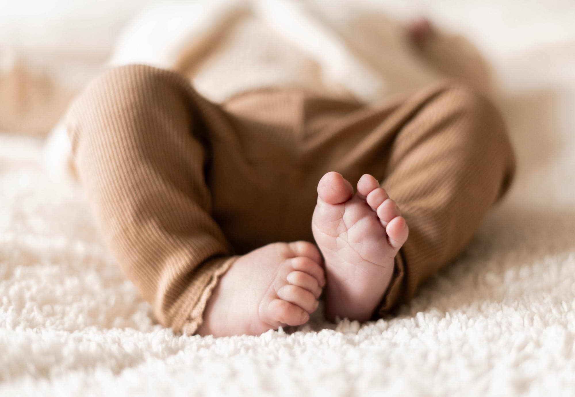 Detail van de voetjes van een pasgeboren baby op een zachte deken