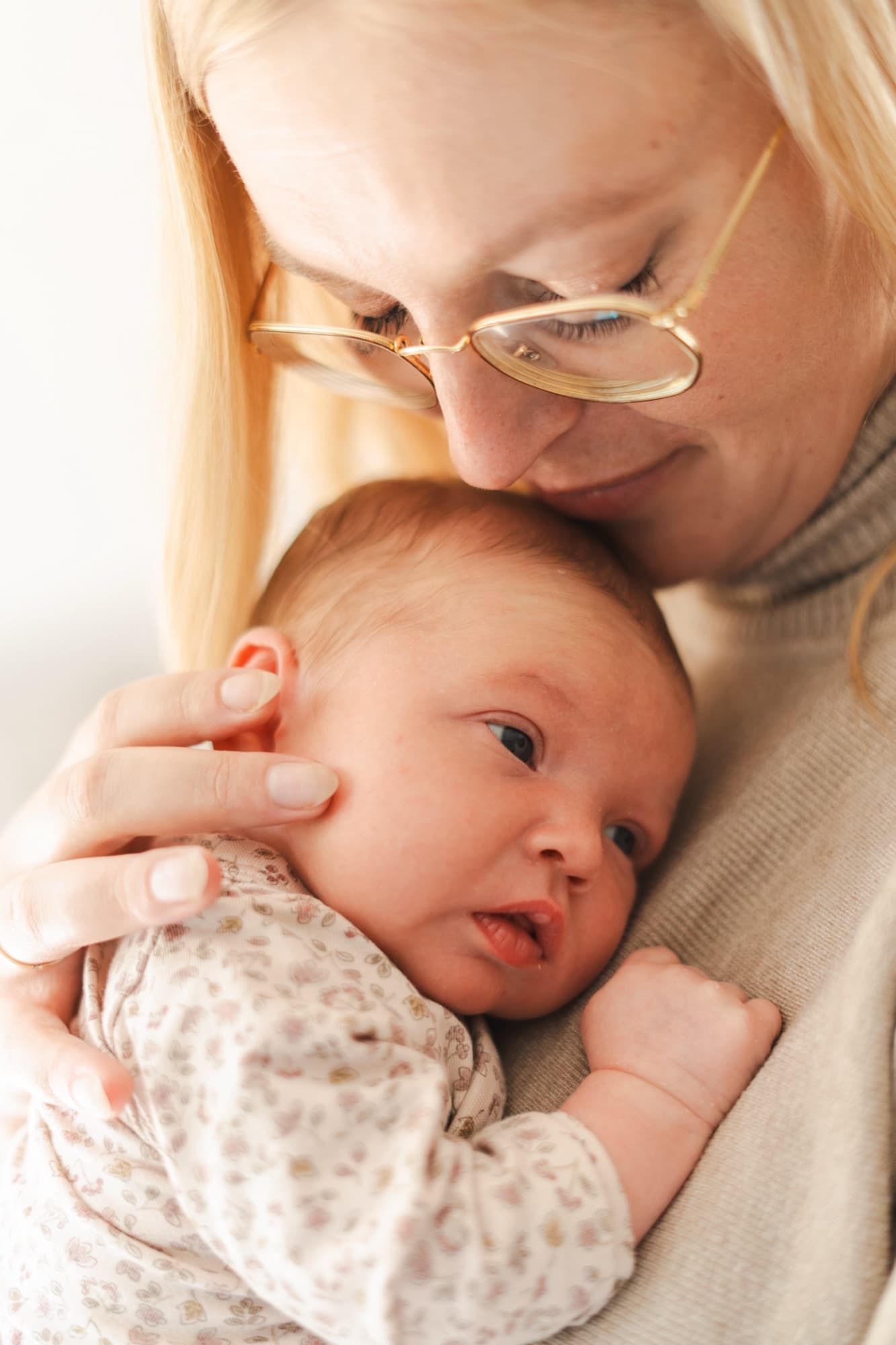 Moeder kust het hoofdje van haar pasgeboren baby tegen haar borst